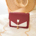 Small messenger bag, wine red with white panel, cat charm clasp, gold chain strap