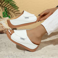 Women’s white wedge slides with open toe, slip-on upper, and brown platform sole