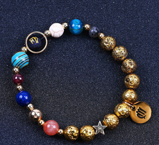 Gold beaded bracelet with blue, maroon, and pink beads plus star and zodiac charms