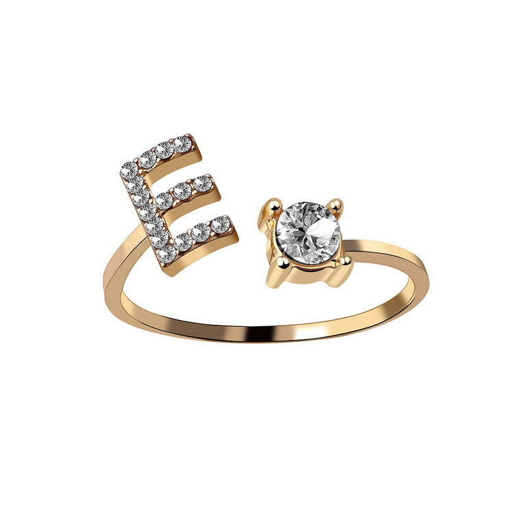 Gold tone initial E ring with round crystal center and pave E detail