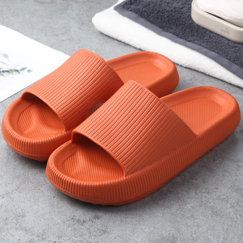 Orange cushioned slide slippers with open toe and textured strap.