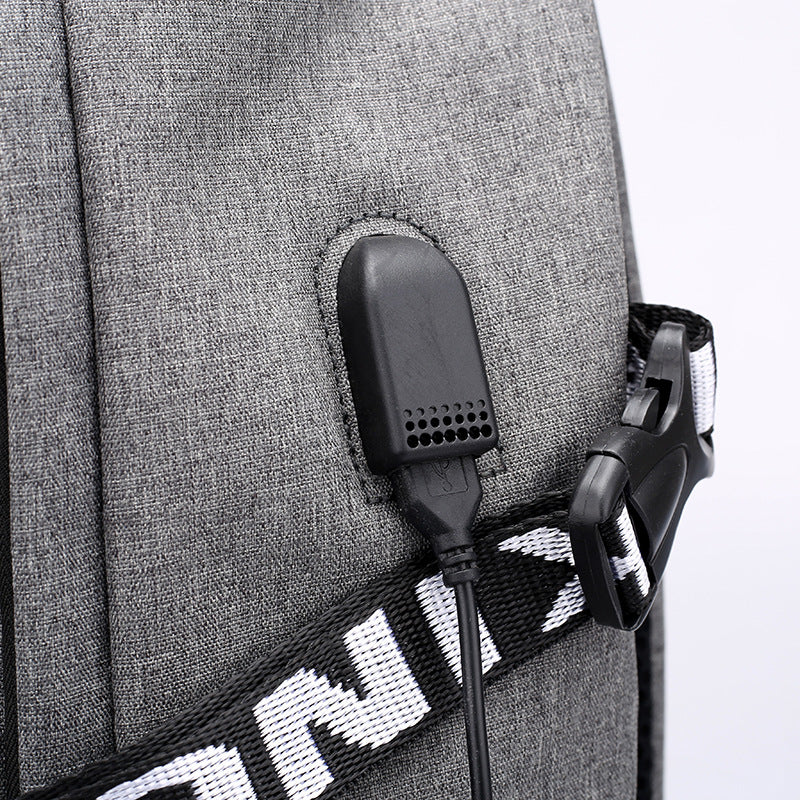 Gray USB charging port panel on a laptop backpack front with black cable
