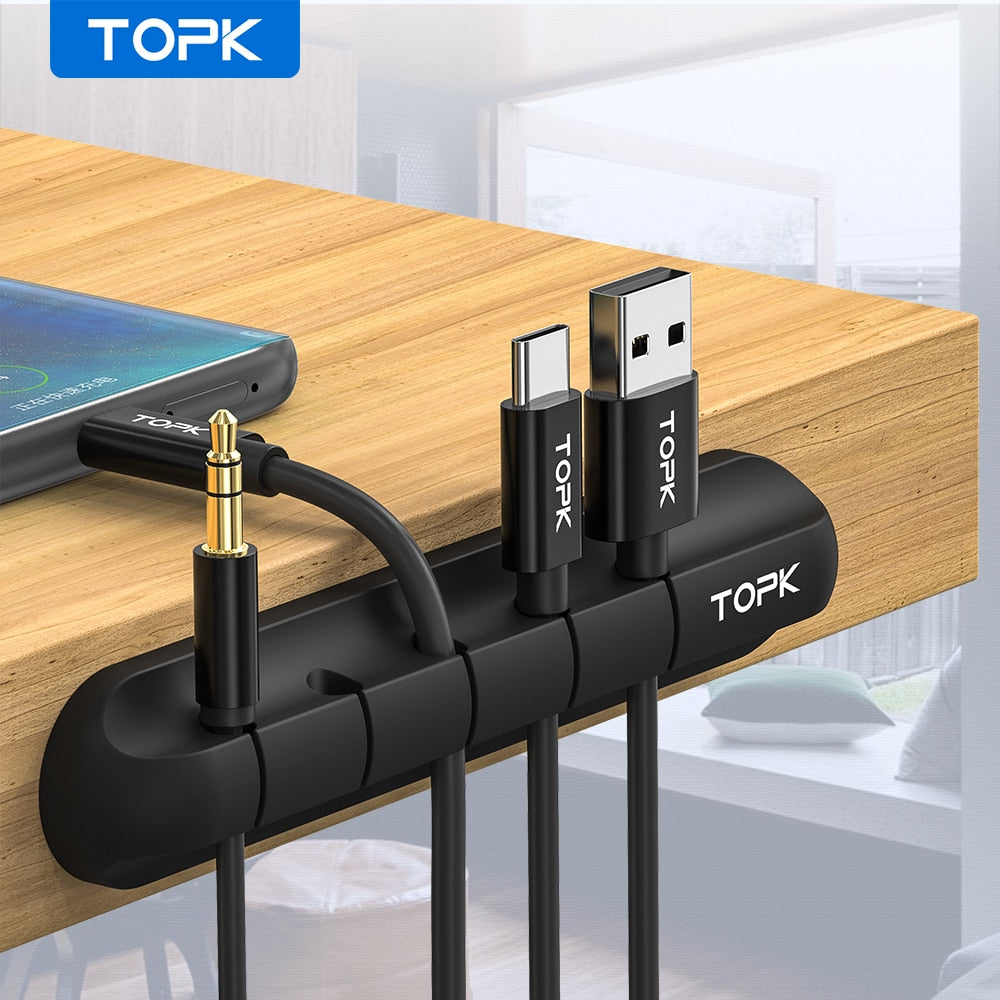Desktop cable organizer with silicone strip holding USB connectors and cables, black