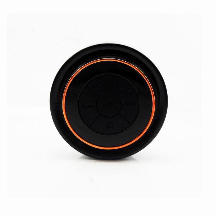 Portable Bluetooth speaker, black body with orange LED ring and circular control panel