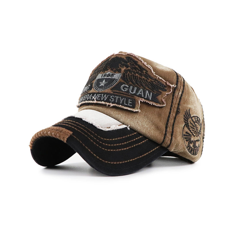 Baseball cap, beige crown with dark visor; front GUAN patch and side feather emblem