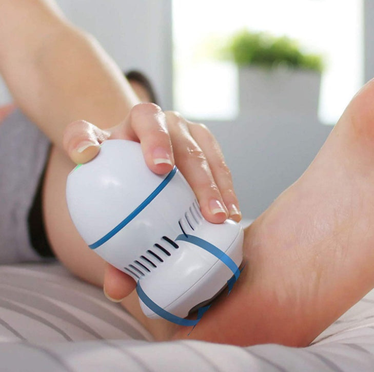 White electric foot file grinder device being used on a bare heel