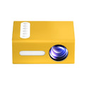 Yellow mini projector front showing lens, remote buttons, and speaker grille
