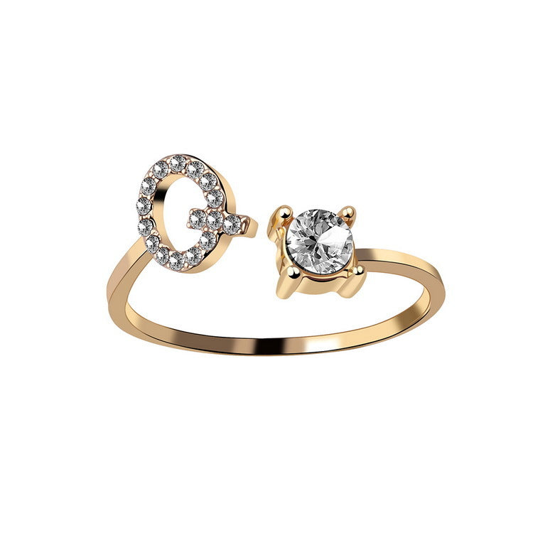 Gold adjustable initial letter ring with pave letter detail and oval center stone.