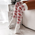 Over-the-knee knit socks in red with white reindeer and snowflake pattern