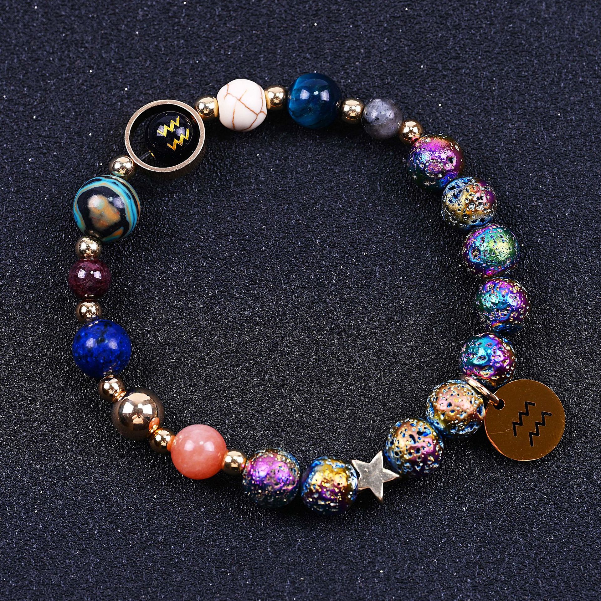 Beaded bracelet with blue, purple and pink stones, star charm, zodiac disc and lobster clasp.