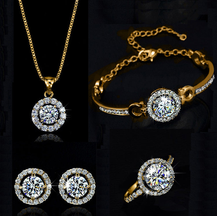 Gold jewelry set with round pendant necklace, matching bracelet, and stud earrings