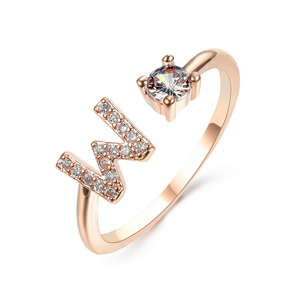 Rose gold adjustable initial ring with W-shaped letter and round center stone.