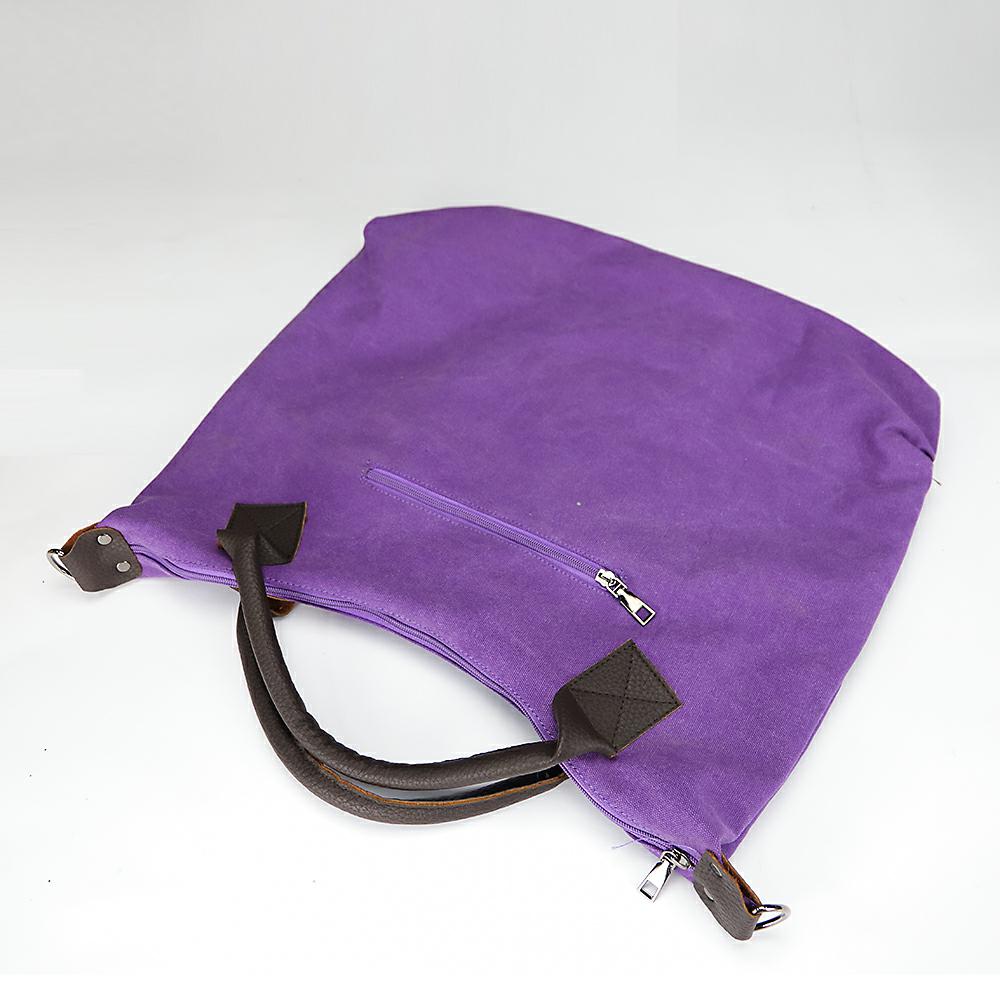 Purple canvas hobo shoulder bag with dark handles and zipper closure, metal rings