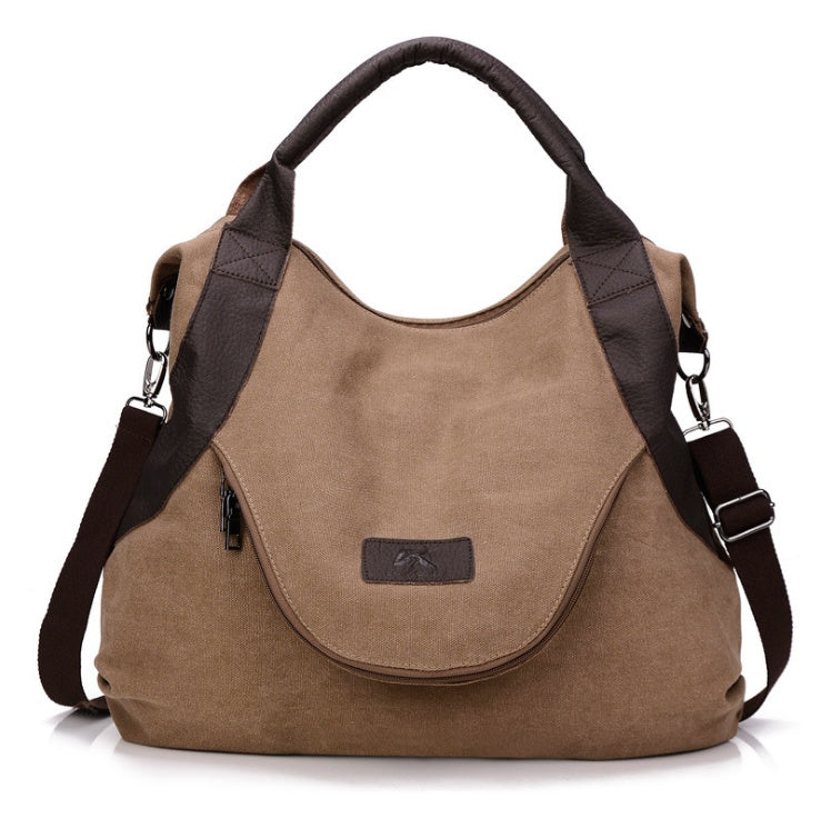 Khaki canvas shoulder bag with dark leather-look trim, top handles, and crossbody strap