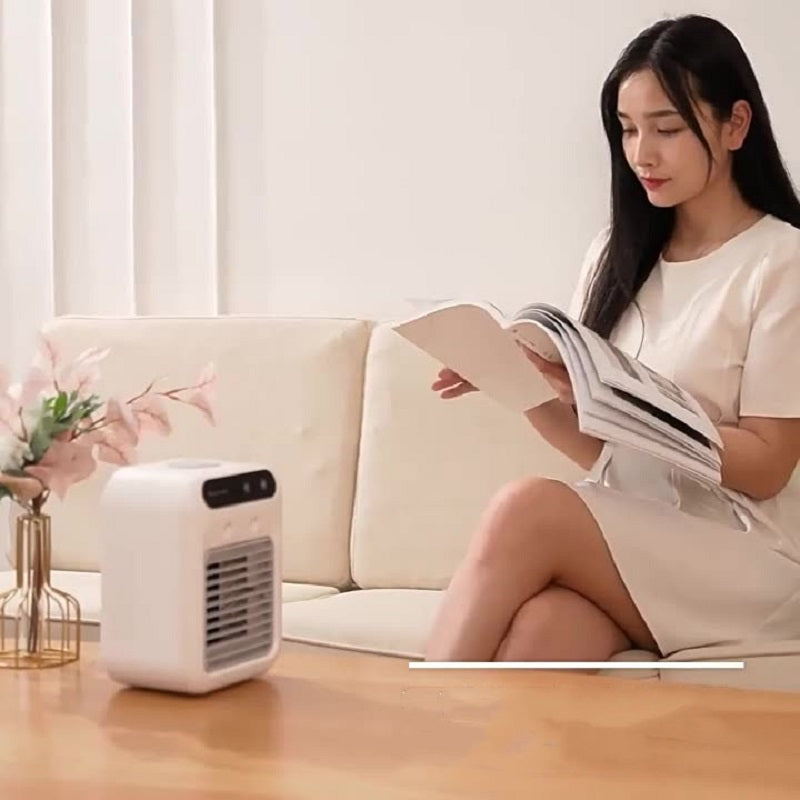 Portable mini air cooler on living room table beside seating, white device