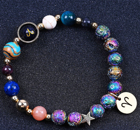 Beaded bracelet with blue, pink, and rainbow-glow beads, star charm, zodiac disc dangle.