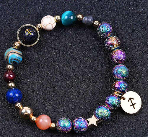 Beaded bracelet with blue, purple, and pink stones; star charm and zodiac disc pendants