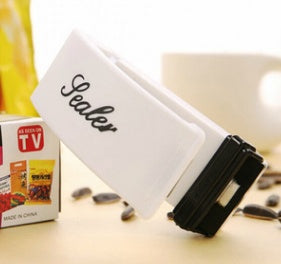 White hand pressure heat sealer close-up with curved top and black latch