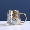 Glass cold water bottle with diamond relief pattern, gold-tone lid and side handle