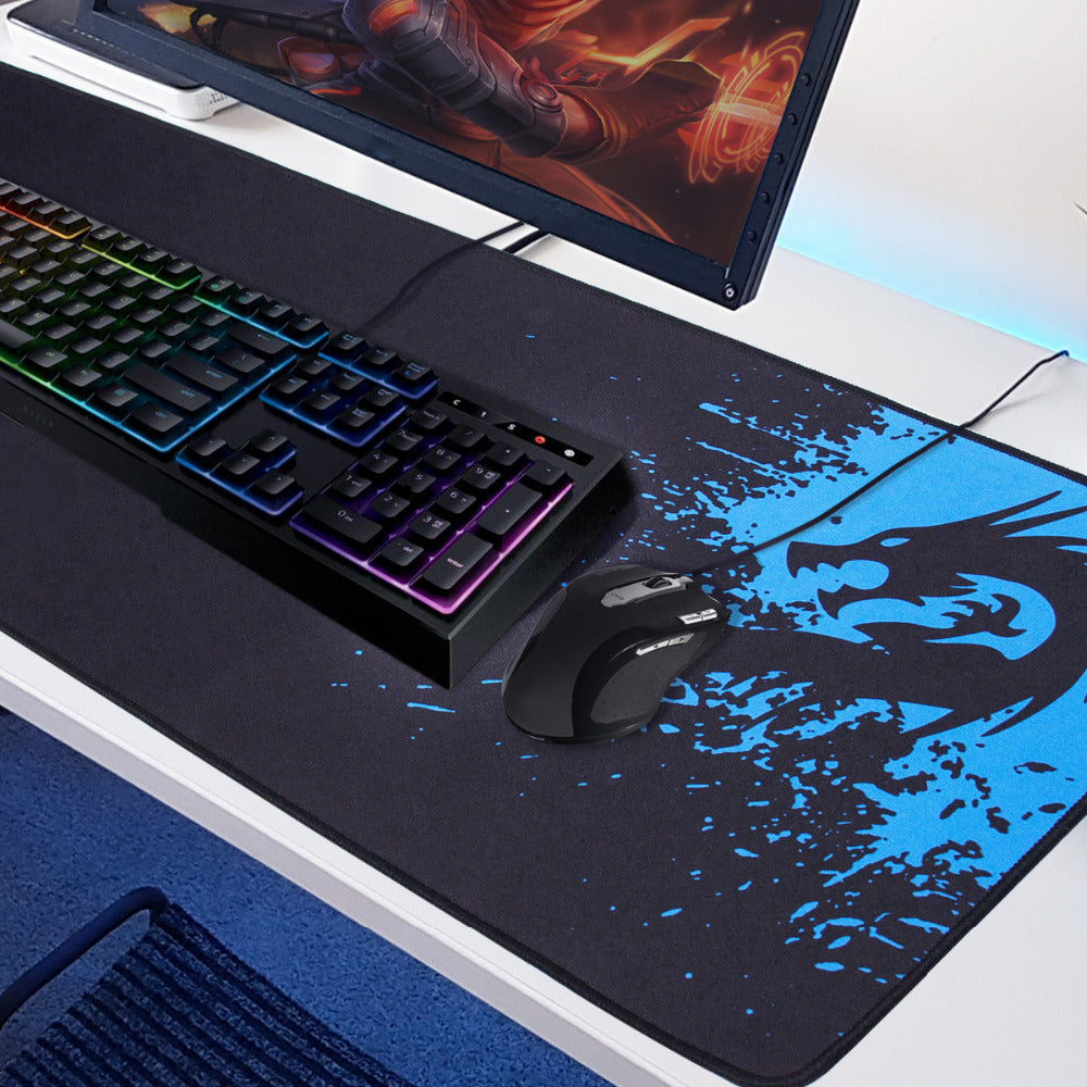 Mouse pad with black surface and blue dragon splatter art, gaming keyboard and mouse shown
