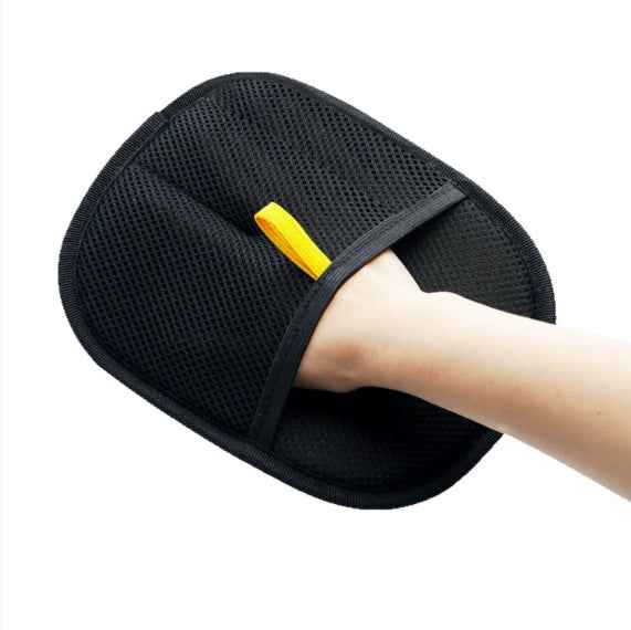 Pet hair removal glove pad in use, black textured surface with yellow insert