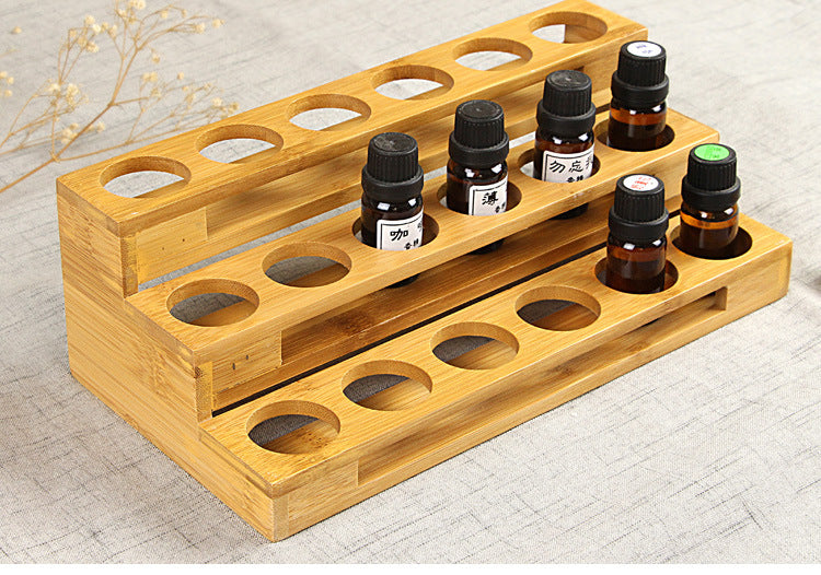 Wood essential oil storage rack with multi-row round holes and several amber bottles