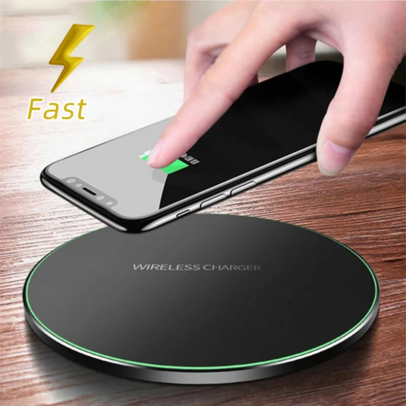 Black wireless charger pad with green LED ring, hands placing a phone on top