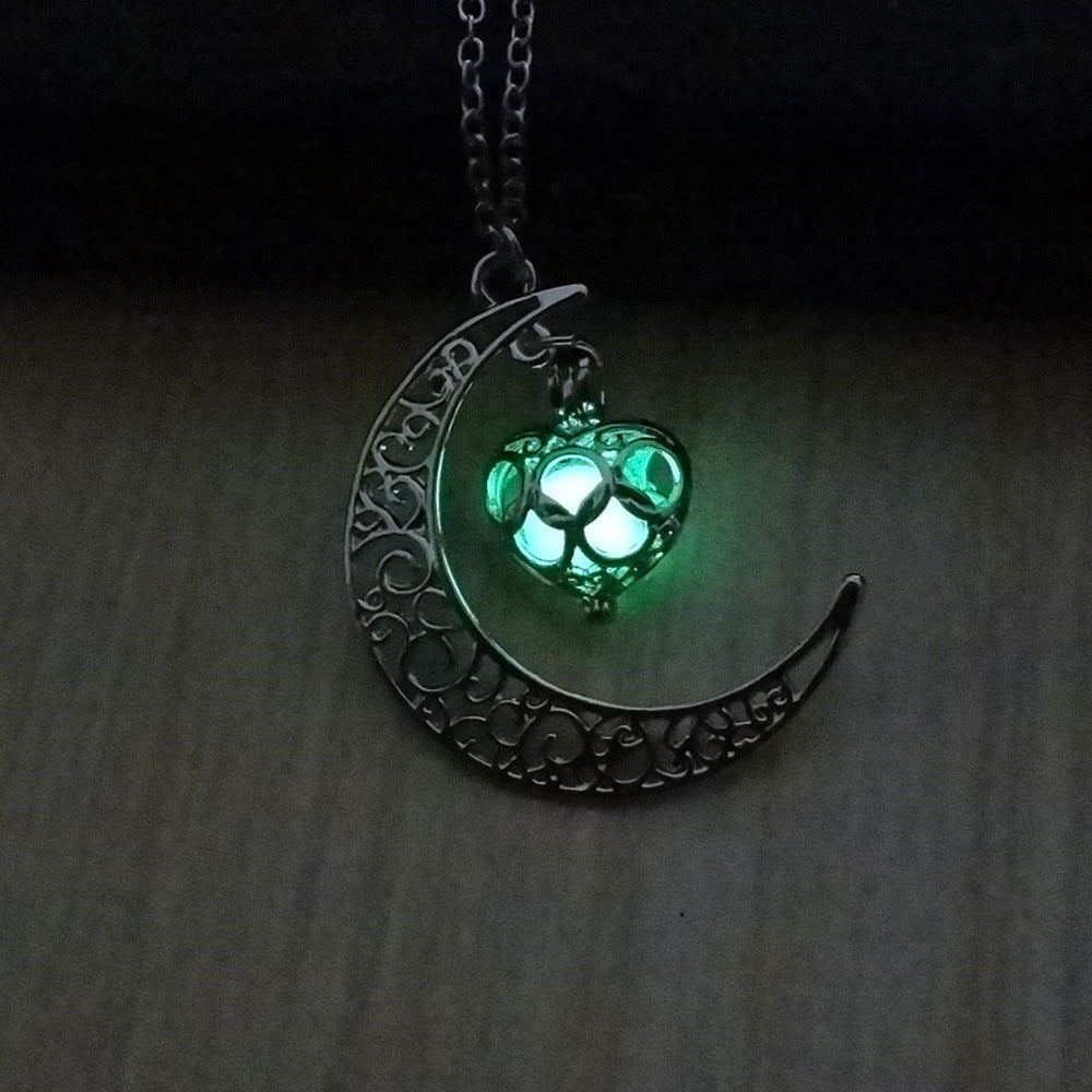 Crescent moon pendant necklace with green glowing cat paw on a silver chain