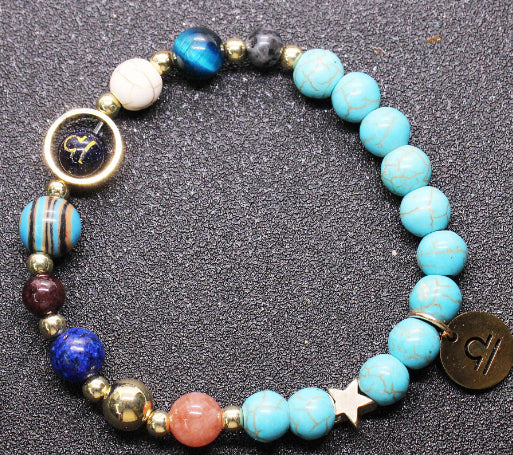 Beaded bracelet with turquoise & blue beads, gold-tone star spacers, zodiac charm disk