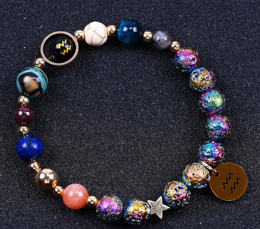 Beaded bracelet with blue and purple speckled beads, pink accents, star charm, zodiac disc.