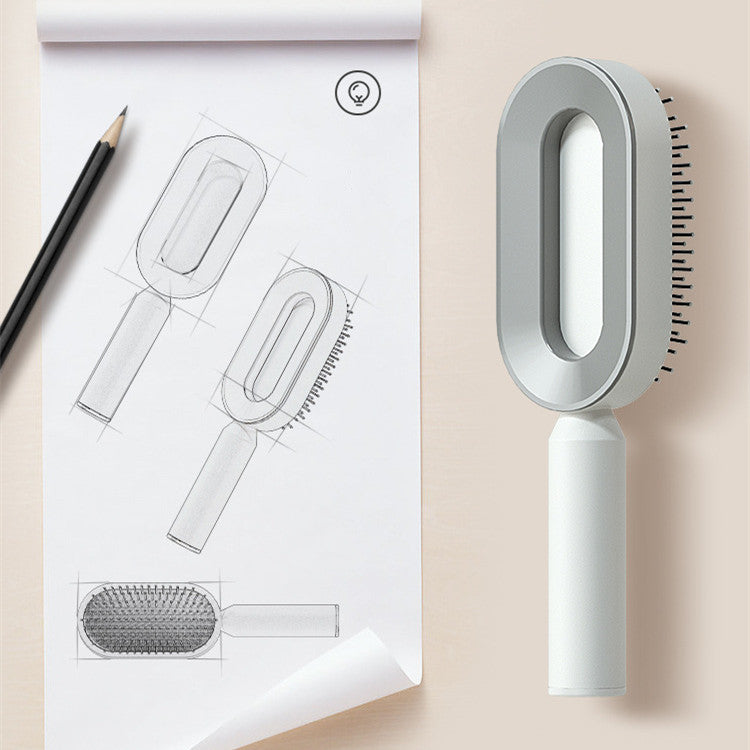 Self-cleaning hair brush with white oval head and gray inner frame on a white handle