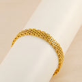 Gold chain bracelet close-up, curved interlocking links