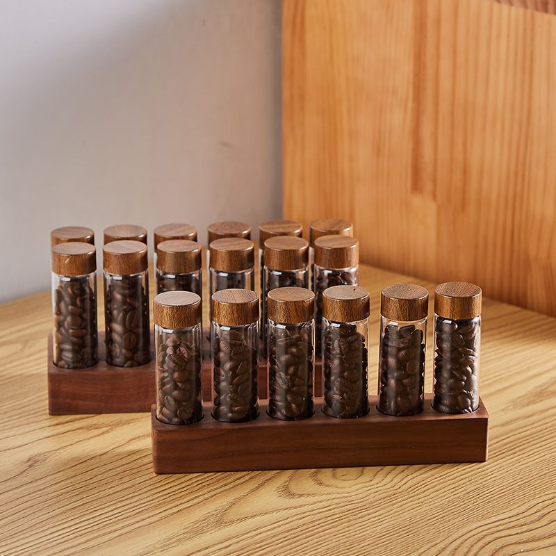 Wooden base with upright clear glass bean bottles and wooden caps