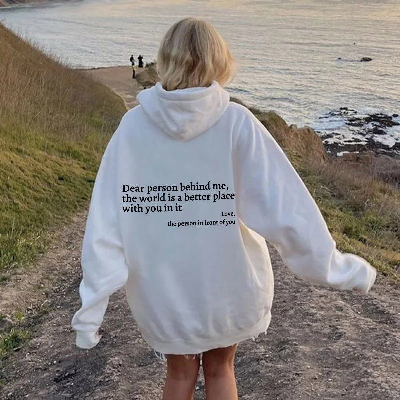White plush hoodie with hood, drawstrings, kangaroo pocket, and printed back message