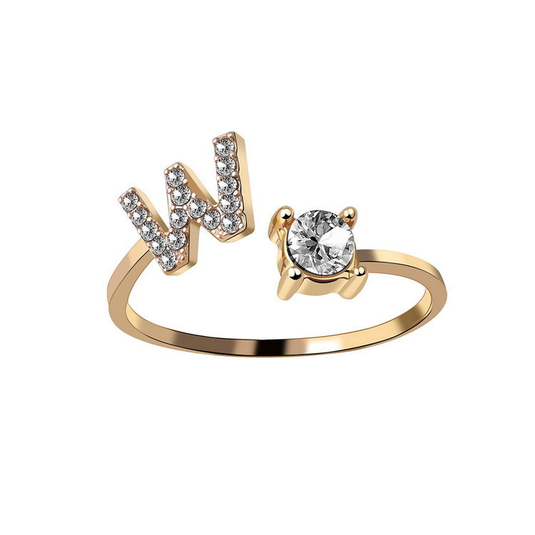 Gold adjustable initial letter ring with pave letter detail and oval center stone.