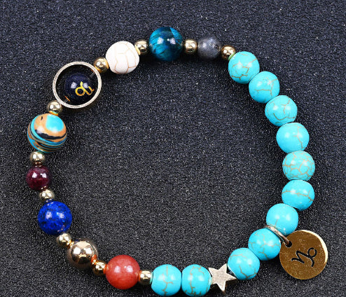 Beaded bracelet with turquoise beads and blue/red accent beads, zodiac charm disks