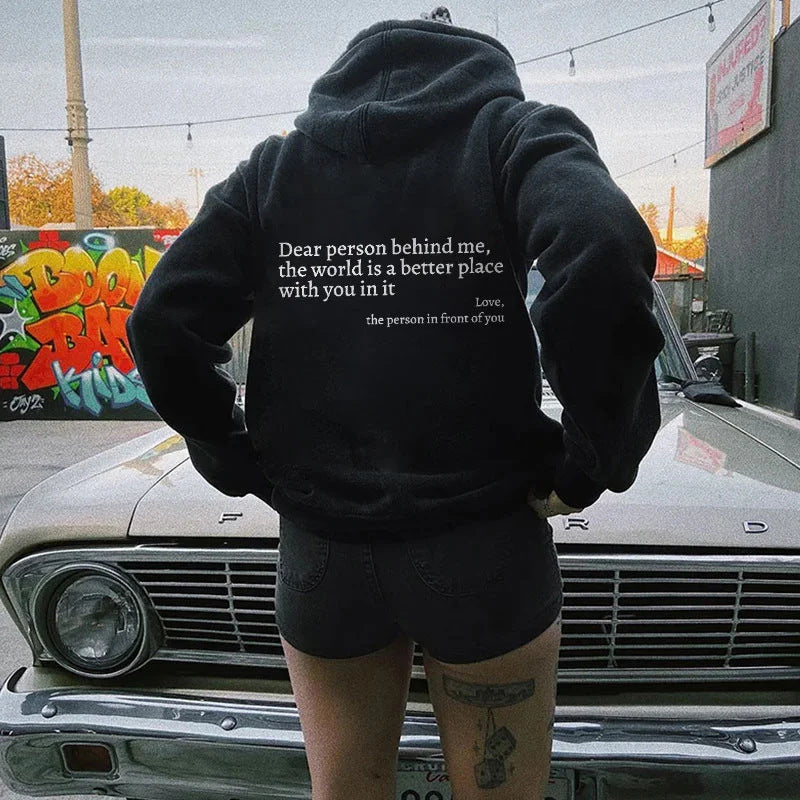 Black plush hoodie with hood, drawstrings, kangaroo pocket, and printed back message