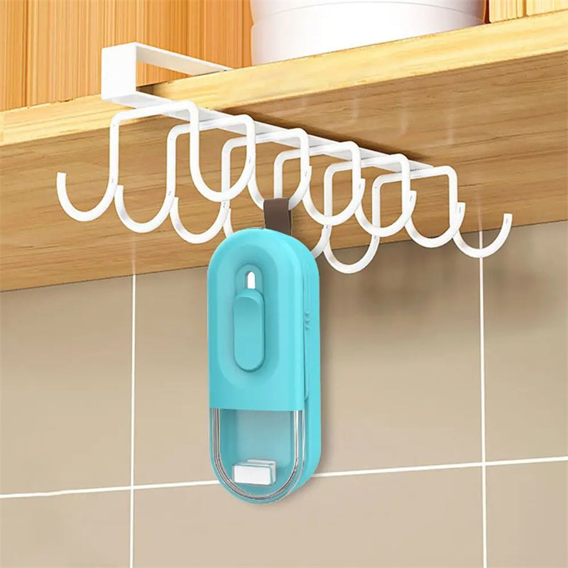 Mini bag sealer hanging on wall hooks, light teal housing