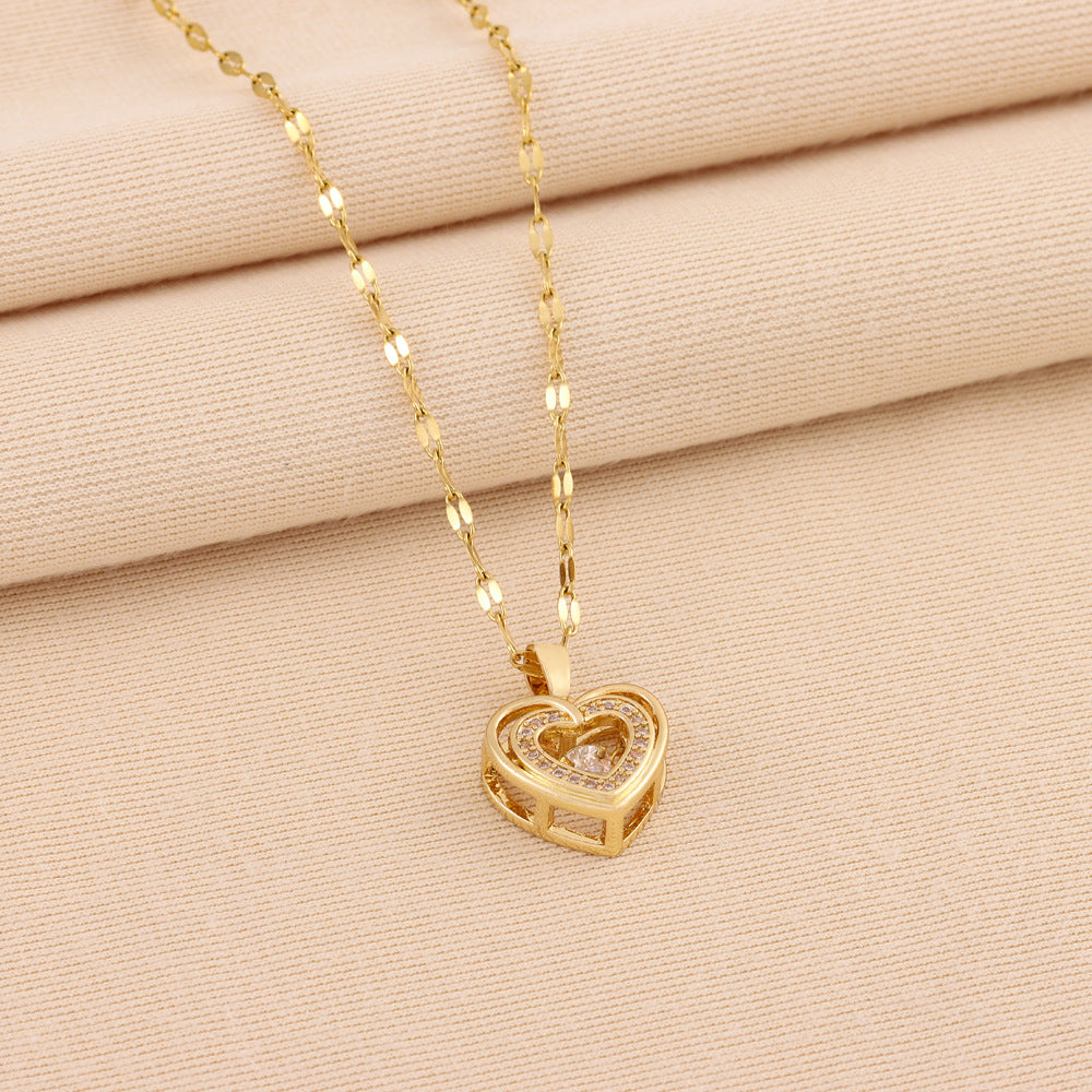 Gold-toned heart pendant necklace with rhinestone love motif on linked chain