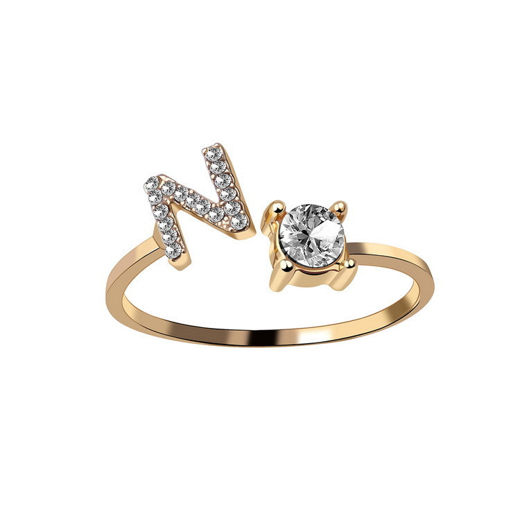 Adjustable initial letter ring with crystal initial and round center stone, gold-tone band