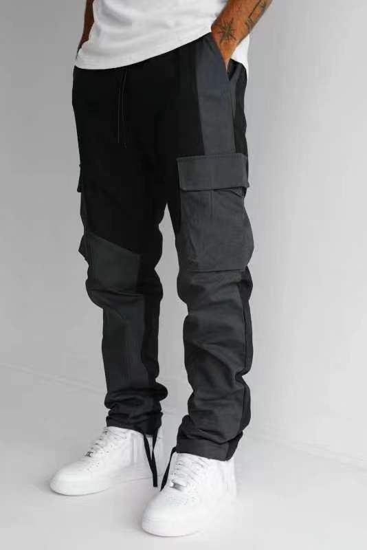 Black cargo trousers with large pocket panel on thigh, loose legs, cuffed hem