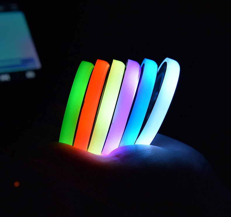 Colorful LED light-up coasters with bright green, orange, purple, and blue rings