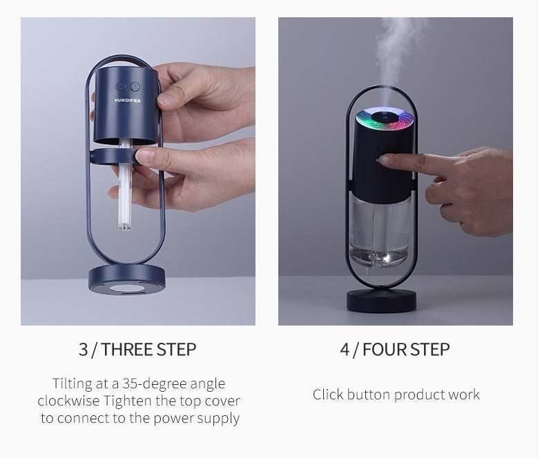 Dark blue USB humidifier held and pressed with hands, showing clear mist chamber