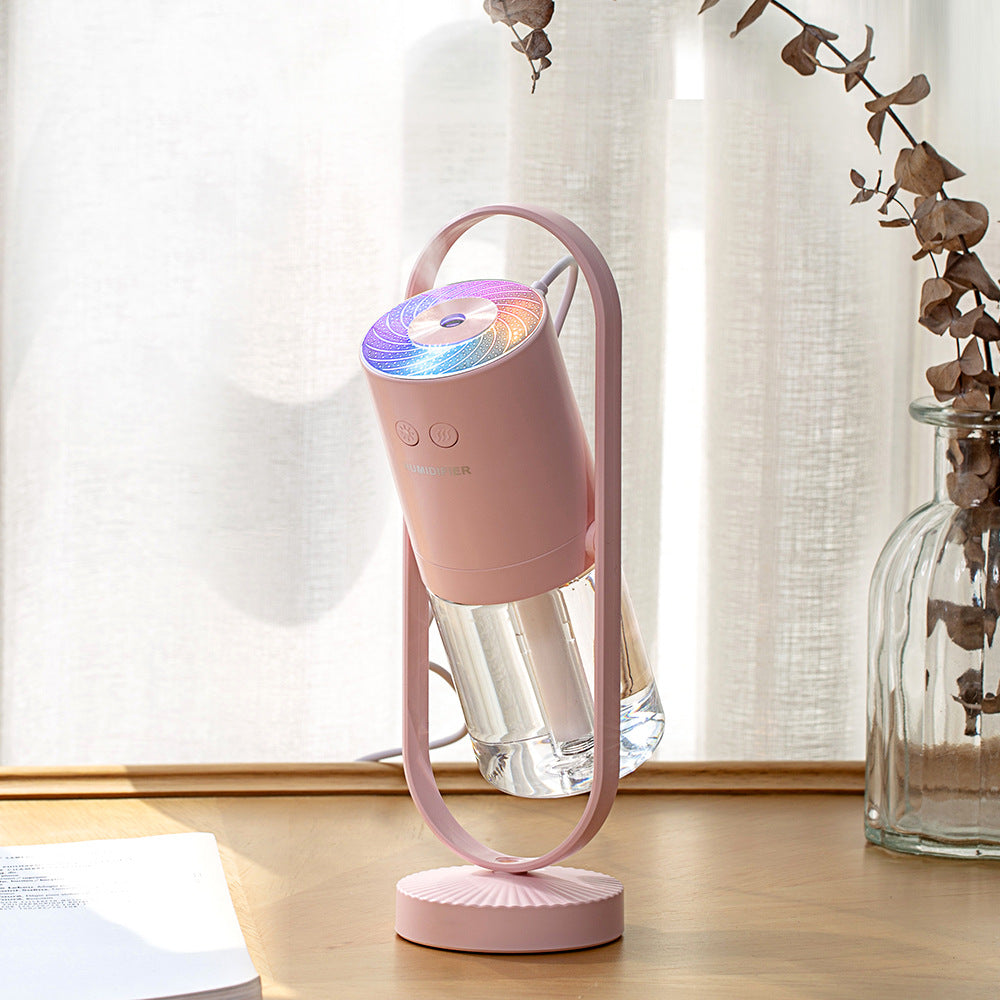 Pink USB air humidifier with clear mist chamber and glowing top on light base
