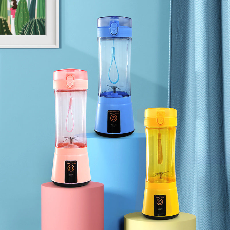 Set of portable electric fruit juicers in blue, pink, and yellow with clear cups