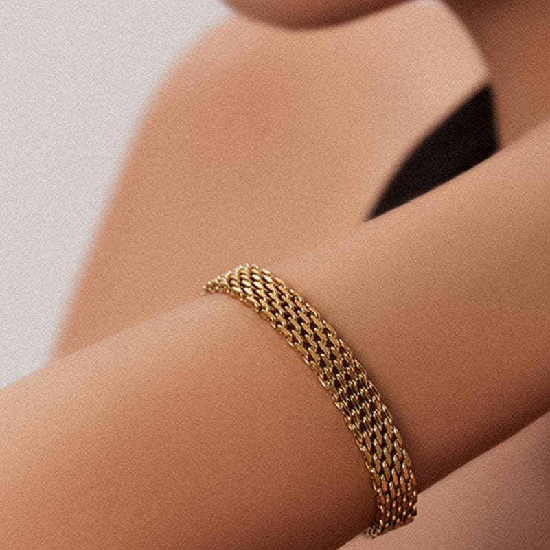 Gold chain bracelet on wrist, multi-row interlocking links