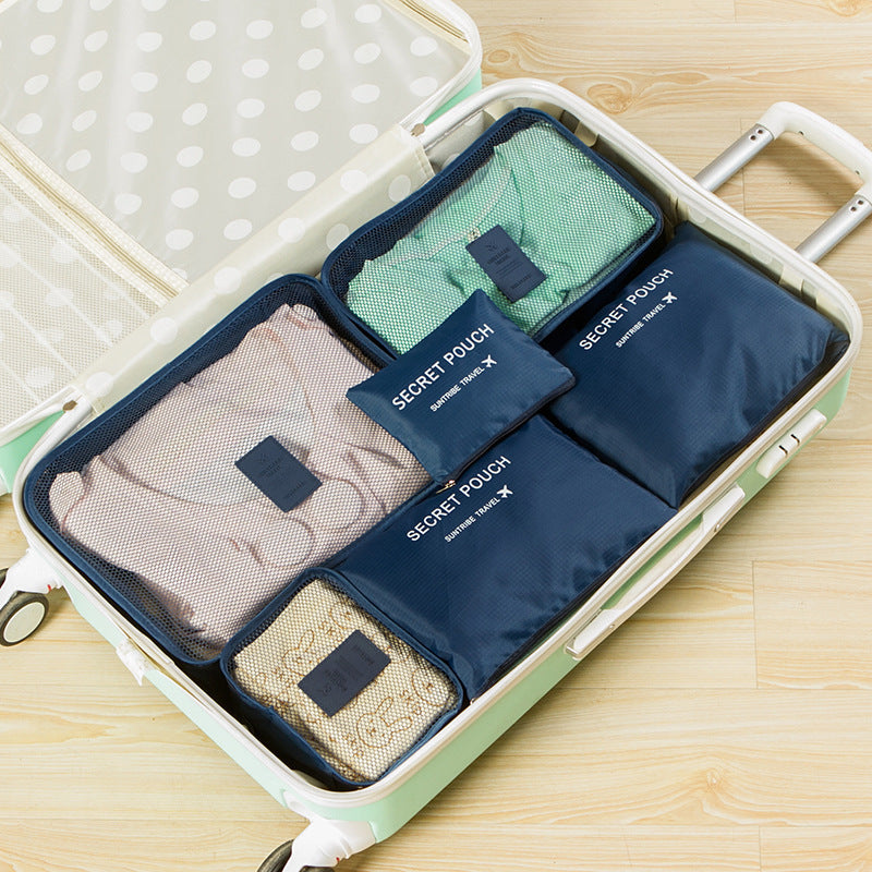 Packing cube set with navy mesh pouches and labeled organizers in a suitcase
