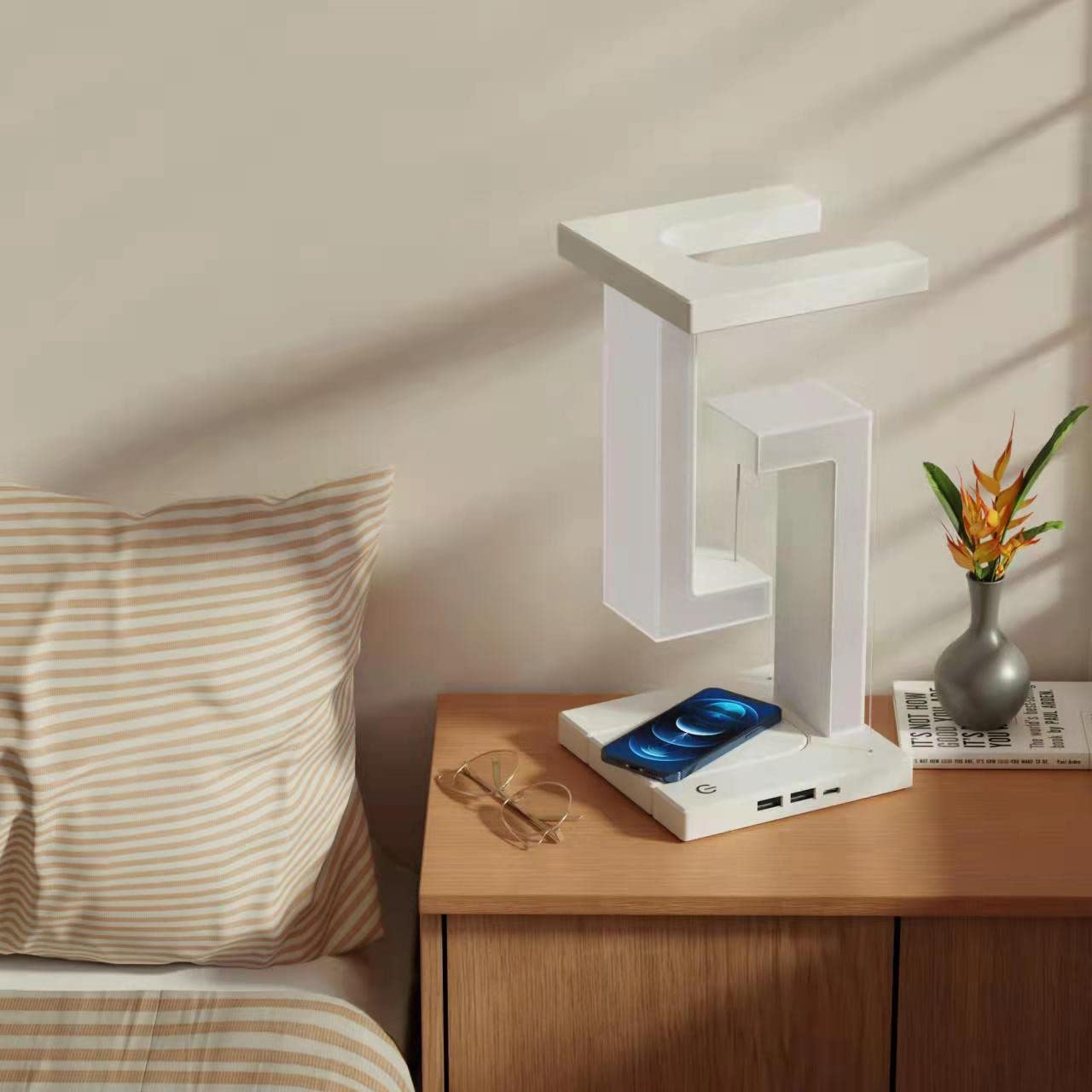 White wireless charging table lamp on base with glowing frame and phone charging pad