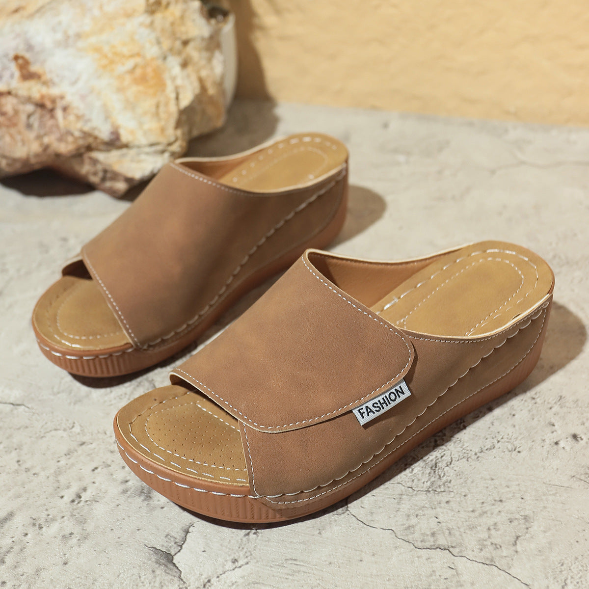 Women’s tan wedge slides with open toe, stitched straps, and brown platform sole