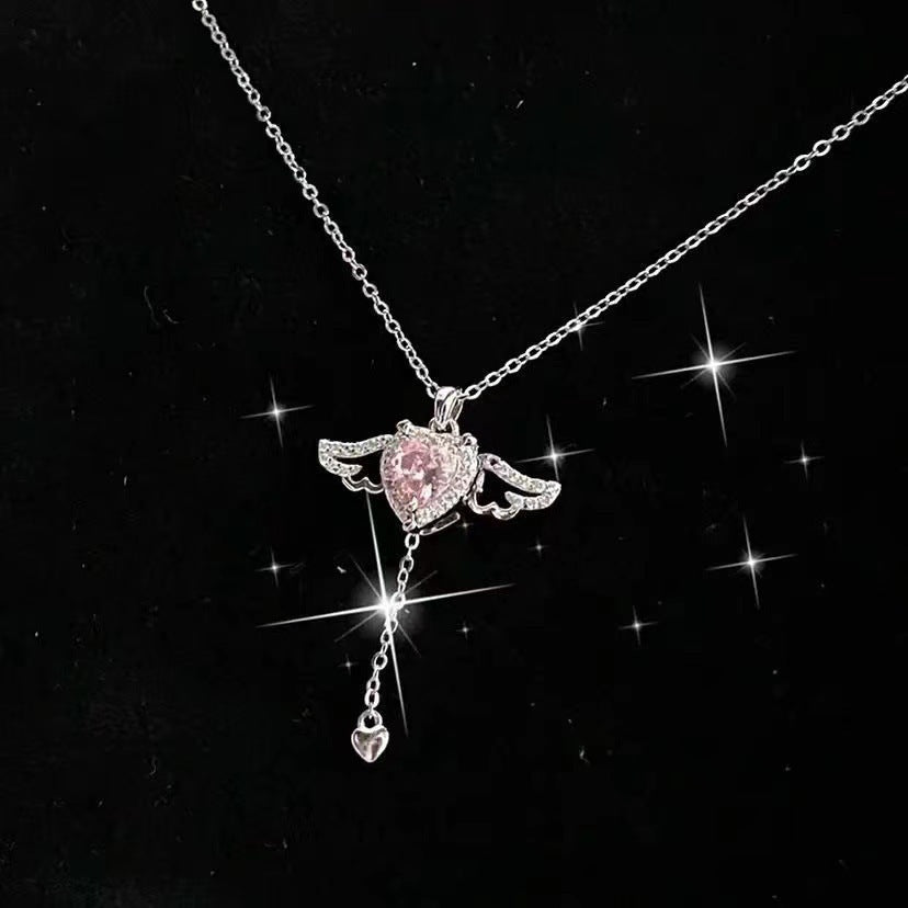 Angel wing heart necklace with pink-toned crystal pendant and dangling heart charm
